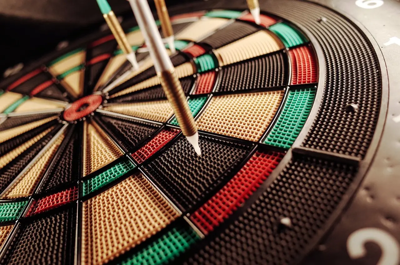 Dartskive med flere pile i tæt nærbillede