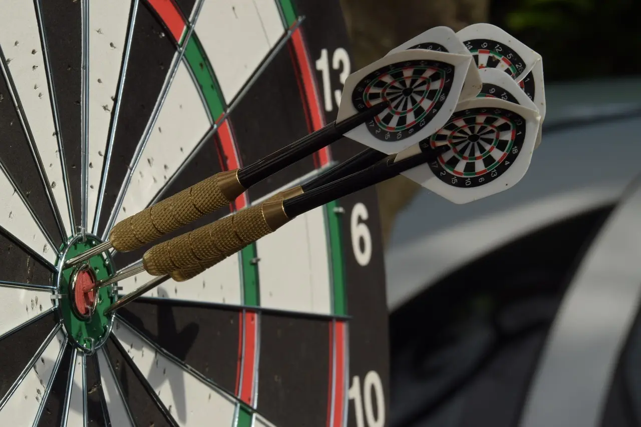 Tre dartpile i bull's-eye på en dartskive